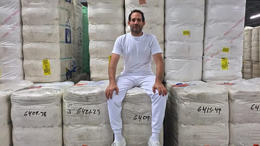 Dov Charney sitting proudly amongst his most recent project